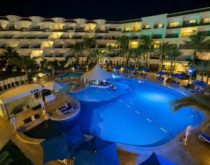 Illuminated-Resort-Swimming-Pool-And-Hotel-Buildings-At-Night-In-Naama-Bay-EgyptaTours